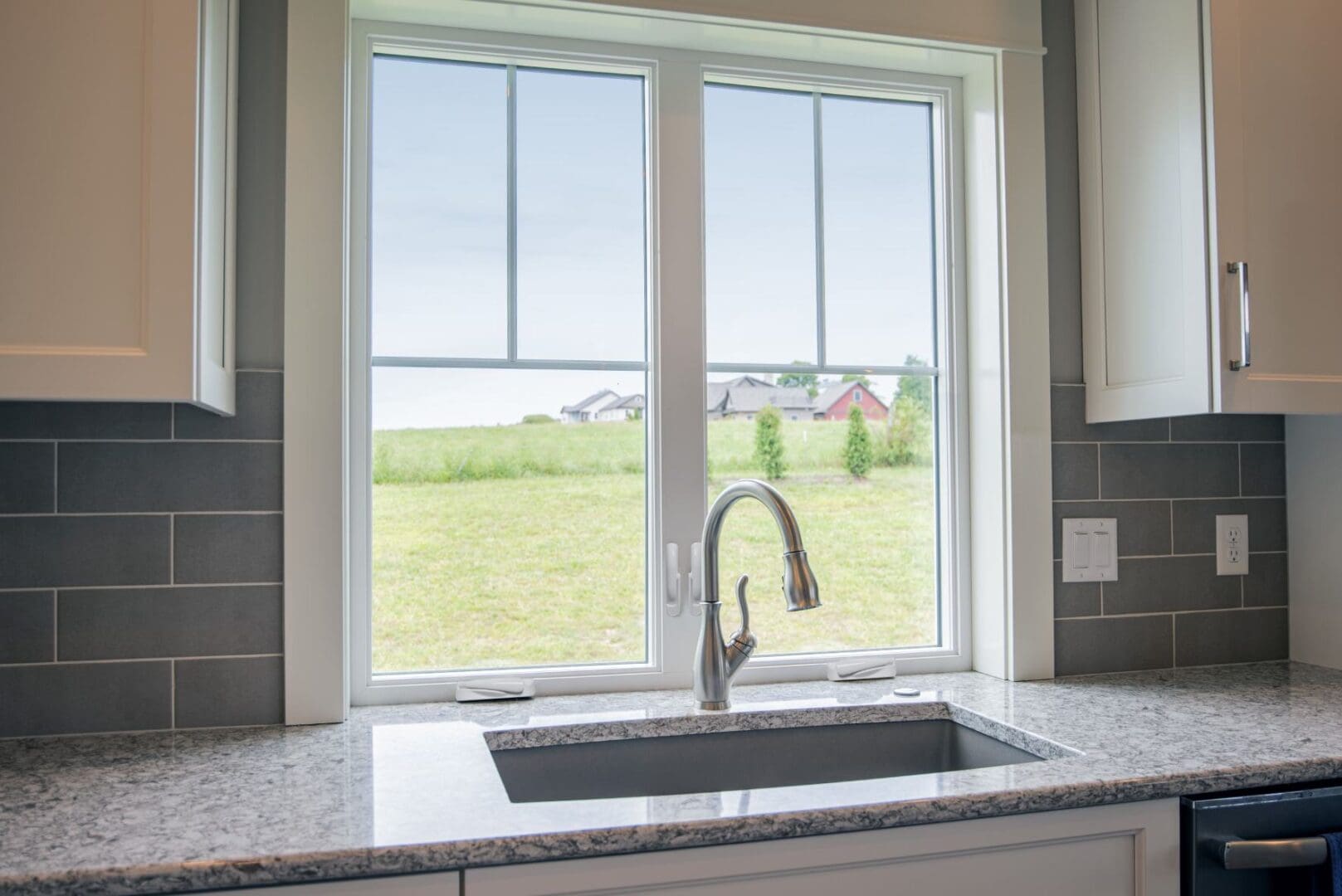 A kitchen sink with a view of the field.