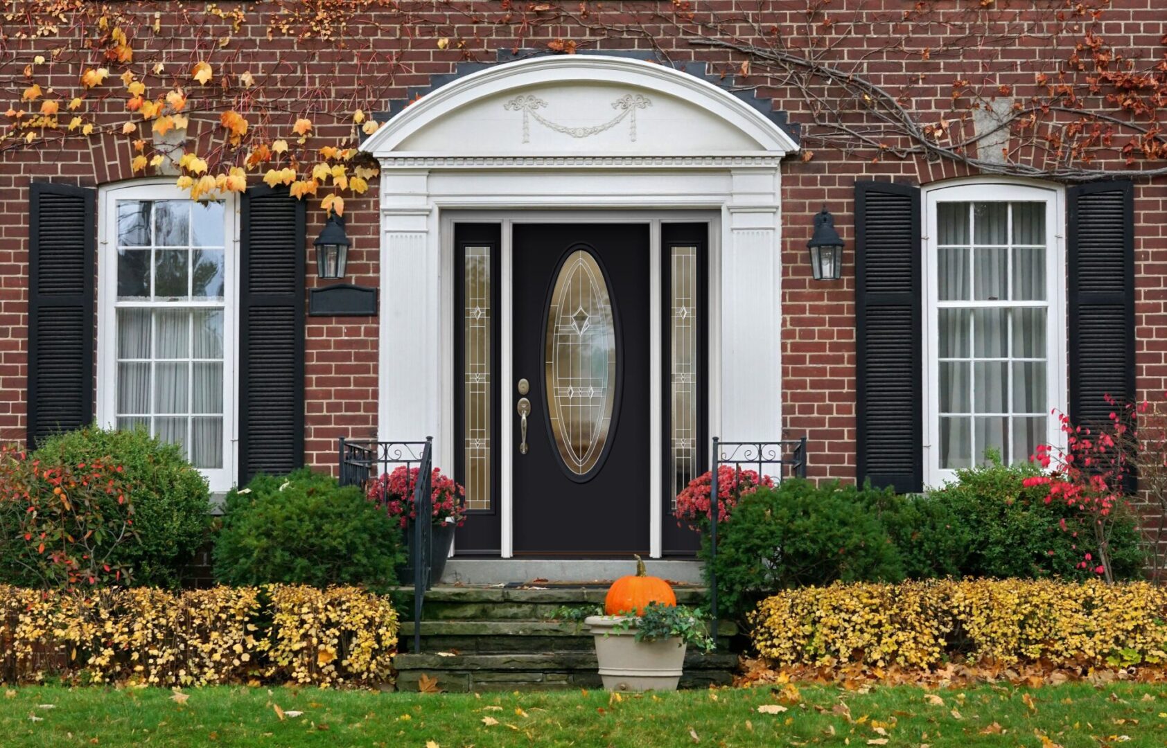 A front door of a house with autumn leaves.