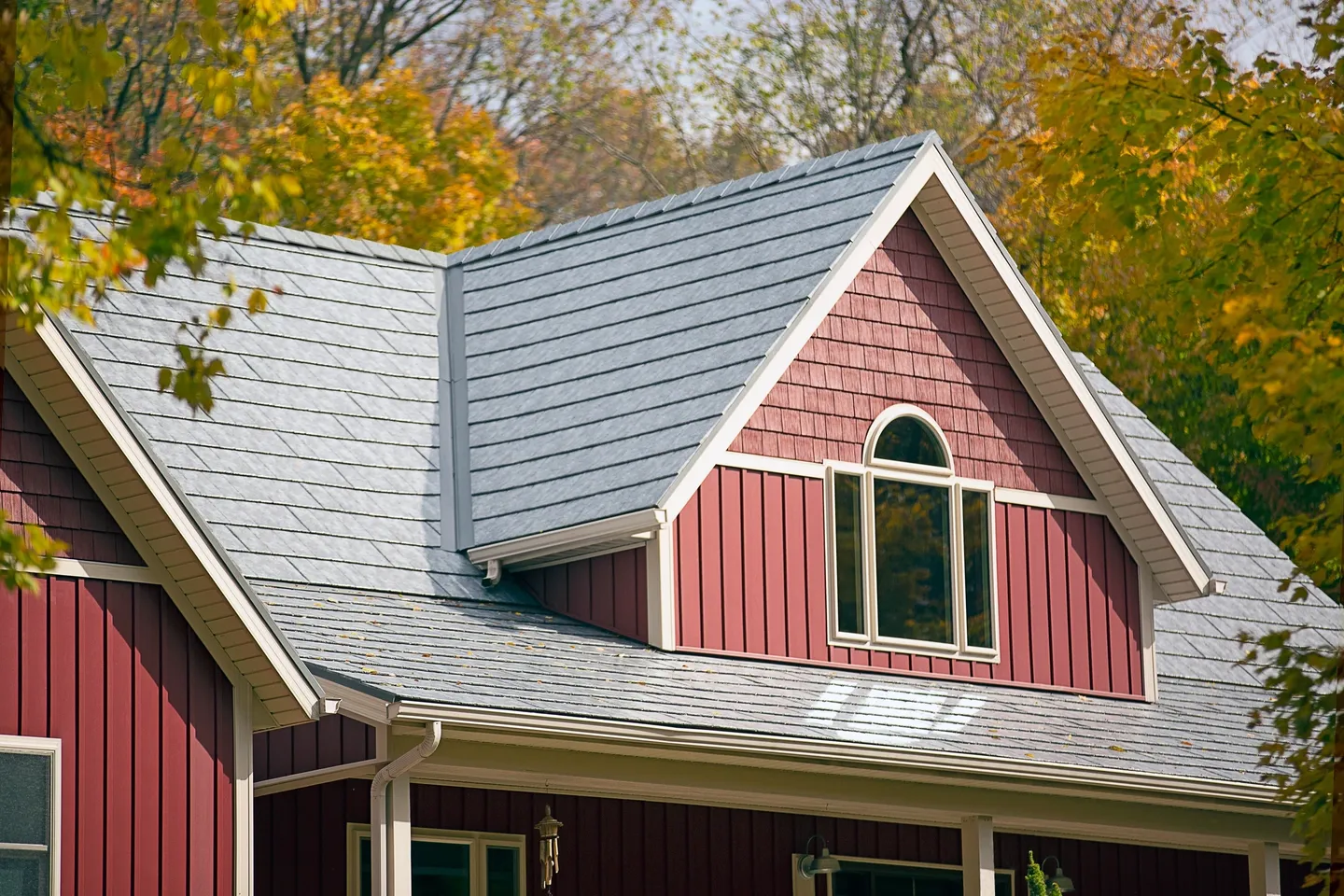 A red house with a metal roof and windows.